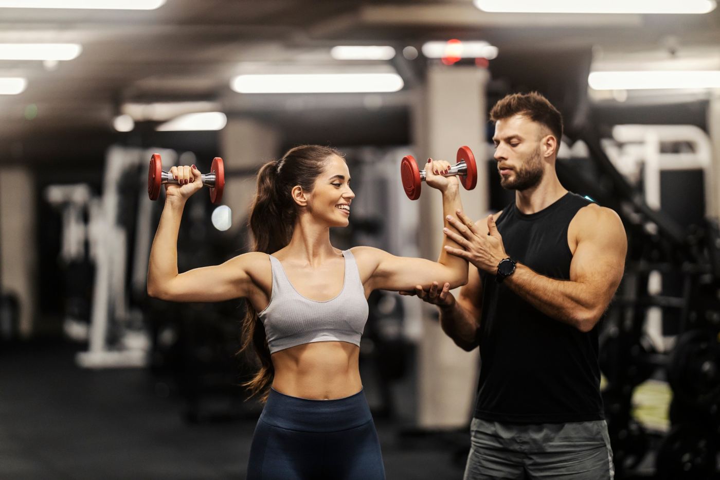 A personal trainer coaching a client with weights